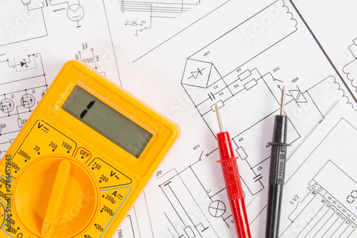 digital multimeter	 and paper electrical engineering drawings 