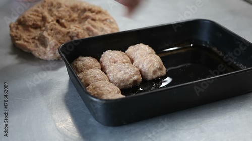 The cook forms round cutlets from the minced meat and places them on a baking tray.