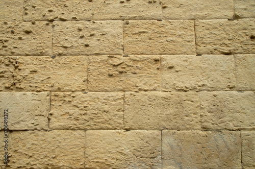 Old stone wall with limestone erosion closeup in Lecce, Italy