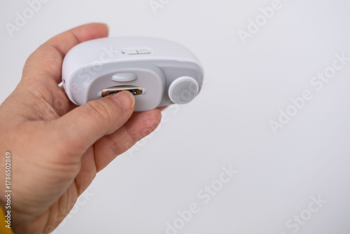 Wallpaper Mural Close-up of an electric nail clipper in hand, modern personal care technology, highlighting compact design and functionality, modern gadget for personal grooming Torontodigital.ca