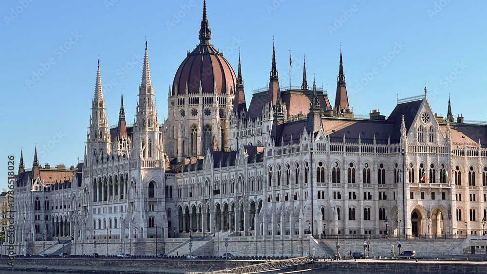 Fototapeta premium Still photo of the Hungarian Parliament Building viewed from the Danube River, showcasing its Gothic Revival architecture and grand riverside presence. 