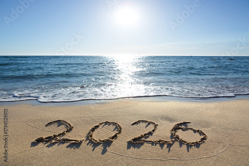 New Year 2026, lettering on the sunny beach sand.