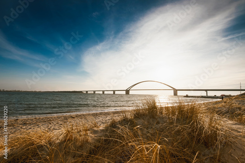 Fototapeta Naklejka Na Ścianę i Meble -  Fehmarnsundbrücke im Licht der Sonne – Küstenidylle an der Ostsee