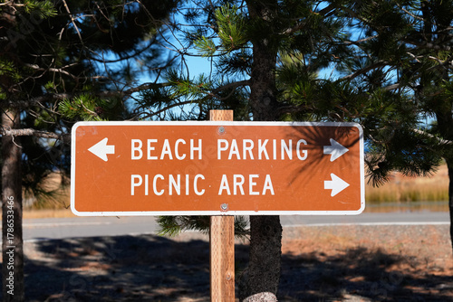 Brown rectangular public lands directional sign with white text and arrows points left to 