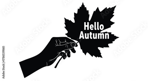Black silhouette of a hand holding a maple leaf with the text hello autumn