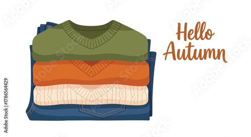 Cozy stack of folded autumn sweaters in warm colors with hello autumn text