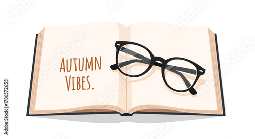Open book with autumn vibes text and black framed glasses resting on the pages