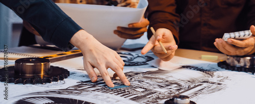Fotografie A group of engineers collaborates on technical drawings, analyzing components and specifications