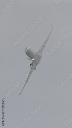 Large white private business Jet during flight under blue sky with clouds