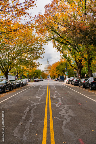 Dramatic fall sky over the U.S. Capitol with colorful trees in foreground