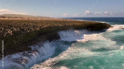 Shete Boka National Park in Curacao. Waves pound against coral rock formations and saltwater splashes high into the air. Cliff-like sea coves.
