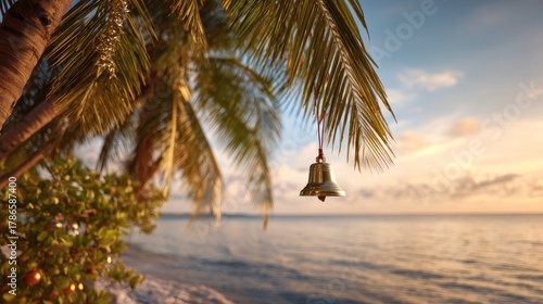 Fototapeta Naklejka Na Ścianę i Meble -  Golden Christmas bell hanging from coconut palm. Sunset beach background