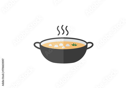 A black pot of steaming light orange soup with white solids and green garnish