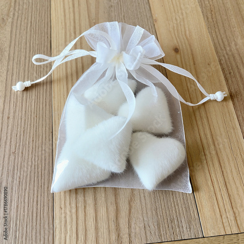 Organza pouch filled with soft heart-shaped decorations for wedding favors and crafting
