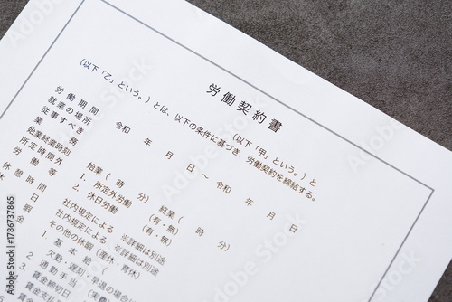 雇用者と労働者の間で労働契約書を交わす
