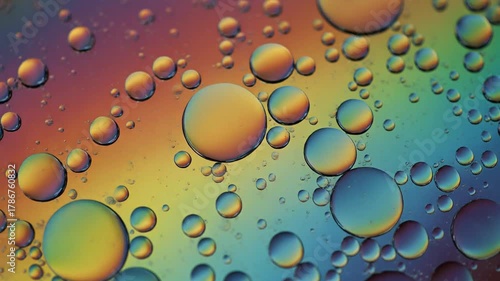 Macro image of oil droplets creating a colorful and vibrant rainbow effect on a liquid surface, abstract background