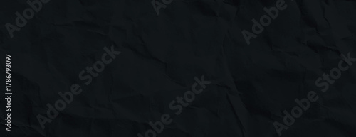 A black background with a crumpled texture. The background is entirely black, creating a dark and textured appearance. Paper texture background vector. Black background.