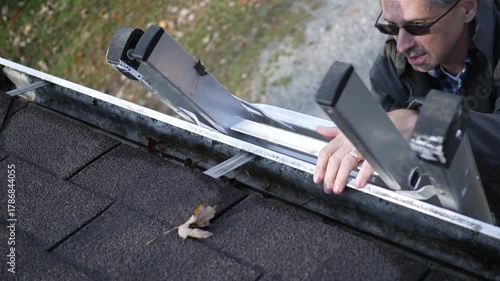 Older Man or Contractor Sets Ladder on Roof