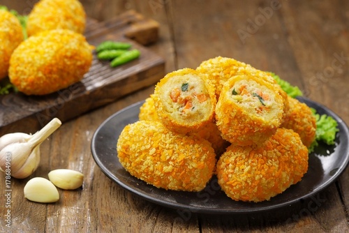 Kroket kentang. Croquettes are lumps of finely mashed potatoes filled with seasoned minced meat and mixed with vegetables such as carrots or green beans. The croquettes are coated with beaten egg and 