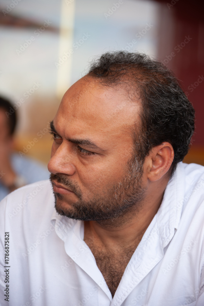 Fototapeta premium portrait of single Egyptian Arab man thinking, sited outdoors at a terrace