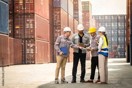 Wallpaper Mural A group of workers are standing in a warehouse, looking at a tablet. They are wearing hard hats and safety vests Torontodigital.ca