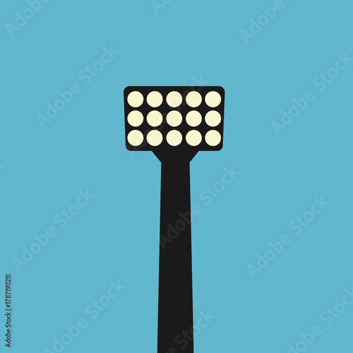 Tall floodlight illuminates a clear blue sky background.