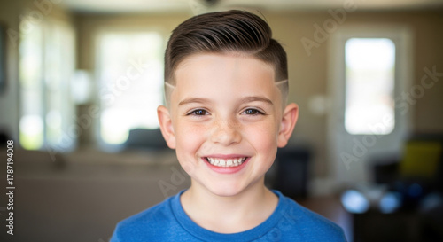 Smiling stylish young boy showing off modern haircut and side shave design