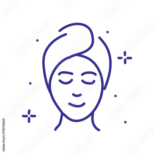 Serene woman with eyes closed wearing a towel on her head, enjoying a moment of self-care and relaxation.