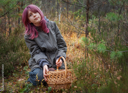 Young girl mushroom picking in autumn forest