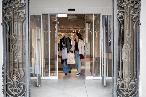 фотографія Happy young women leaving store after shopping