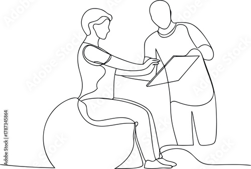 Person on exercise ball with trainer looking at tablet