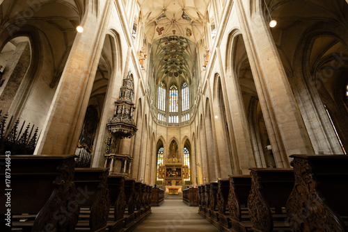 Kutná Hora, Czech Republic – August 8, 2025: Central nave of St. Barbara’s Cathedral with wooden pews leading to ornate Baroque altar and Gothic vaulted ceiling in Kutná Hora