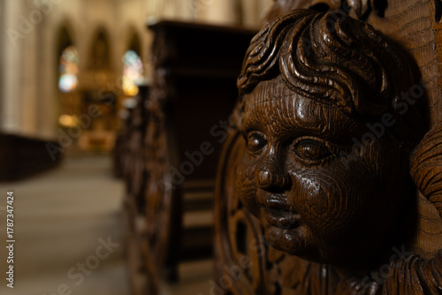 Kutná Hora, Czech Republic – August 8, 2025: Detailed wood carving of face on historic church pew inside Cathedral of St. Barbara, Kutná Hora, UNESCO World Heritage Site