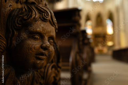 Kutná Hora, Czech Republic – August 8, 2025: Detailed wood carving of face on historic church pew inside Cathedral of St. Barbara, Kutná Hora, UNESCO World Heritage Site