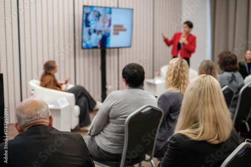Wallpaper Mural Audience listens to speaker presenting at conference room with screen slides. Professional setting conveys learning training business collaboration among diverse attendees. Torontodigital.ca
