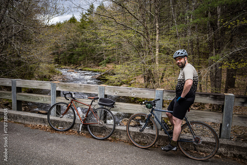фотографія A man pauses near a stream while riding gravel bikes