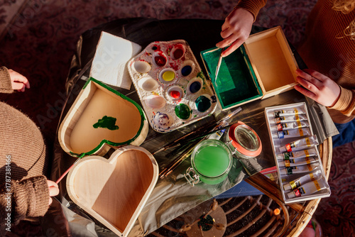 Photography Children painting wooden boxes with colorful paints on table