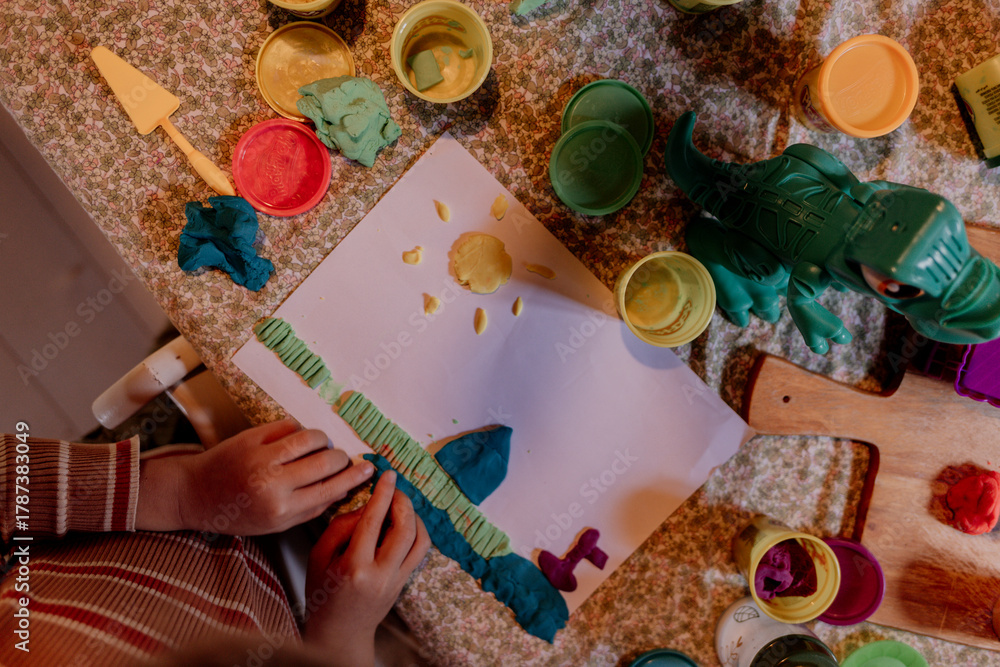 Fototapeta premium Child crafting sun and shapes with colorful playdough
