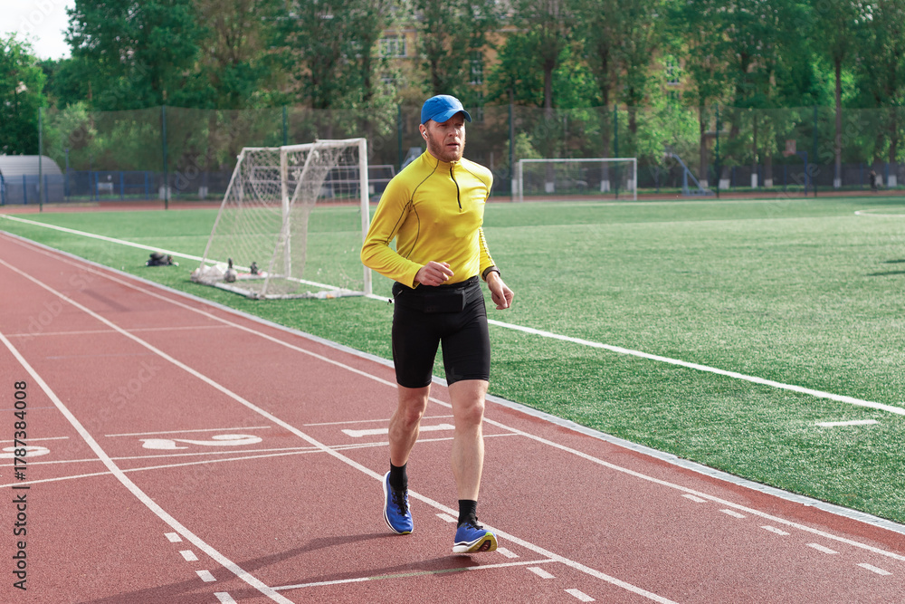 Obraz premium Runner passing football goal at stadium