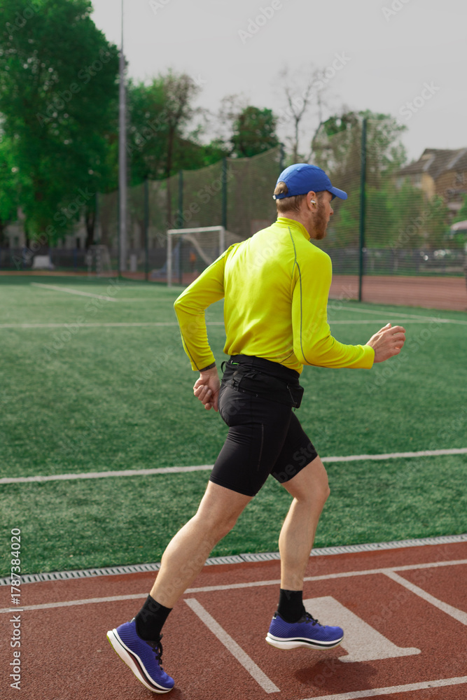 Obraz premium Runner jogging near football field
