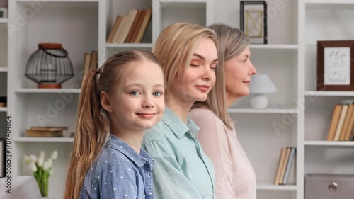 Cute little girl posing indoors with young mother and senior grandmother, side profile view, closeup portrait. Lifespan, next generation, offspring and heredity. For Mothers Day.