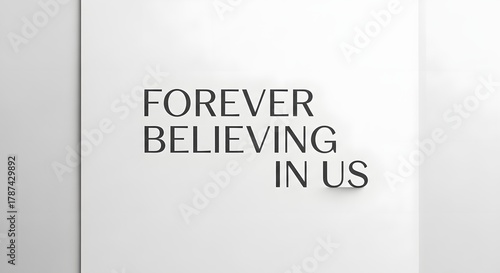 Inspirational quote on a plain wall that reads 'Forever believing in us' in a modern, minimalist style with clean typography and neutral background
