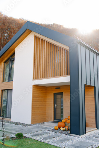 Modern cozy home exterior with autumn pumpkins