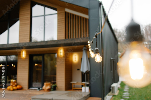 Modern cabin exterior with string lights illuminating patio
