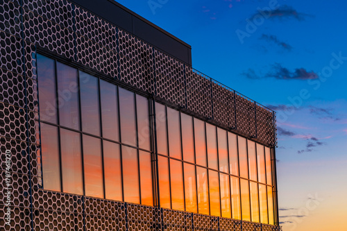 Stunning sunset colors reflecting on windows of a building in Molndal