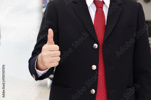 Medium shot business man body in black suit with hand Thumbs up on the indoor background. business on background.