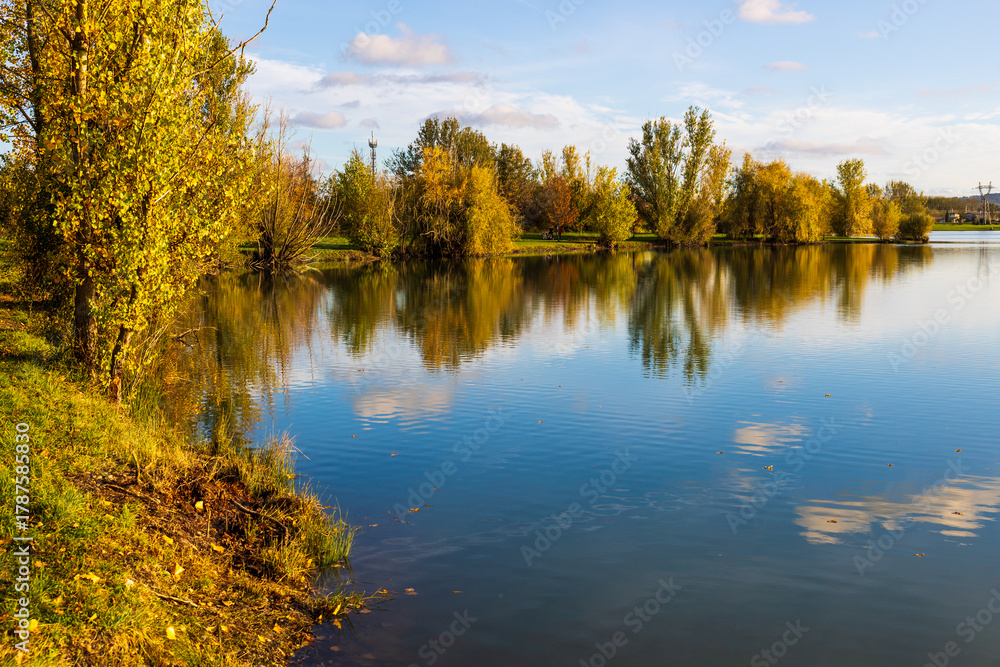 Fototapeta premium Banks and lawns around Lake Sabatouse in autumn in Longages