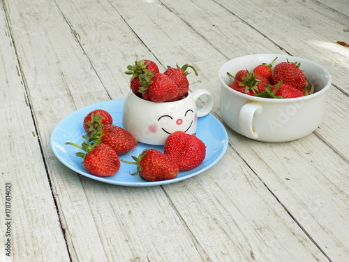 strawberries in a bowl on wooden table