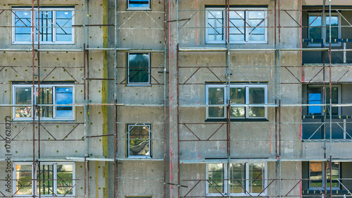 Fototapeta Naklejka Na Ścianę i Meble -  Close view of apartment building facade with scaffolding during renovation, construction and modernization work in city