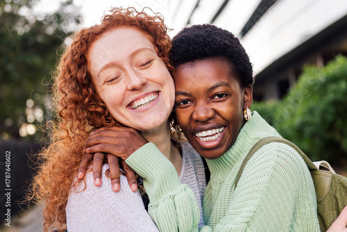 portrait of two young women hugging and laughing happy, concept of youth and friends lifestyle